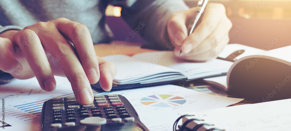 Close up hand man doing finance and calculate on desk about cost at home office.