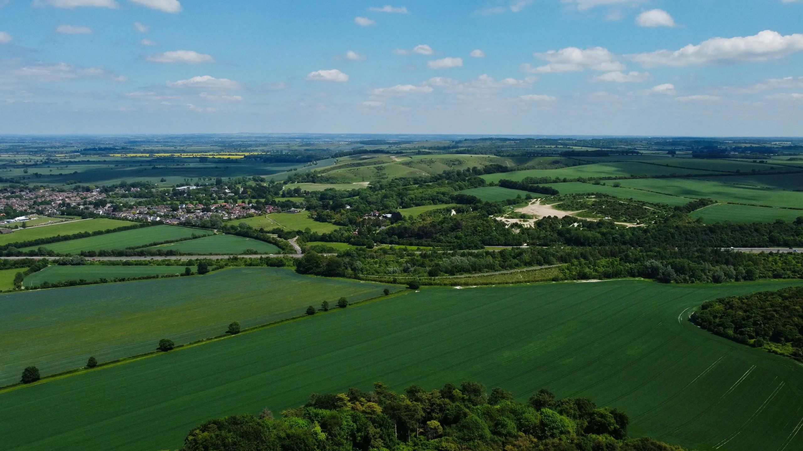 Aerial shot of lush green fields and rolling hills in Central Bedfordshire, England.