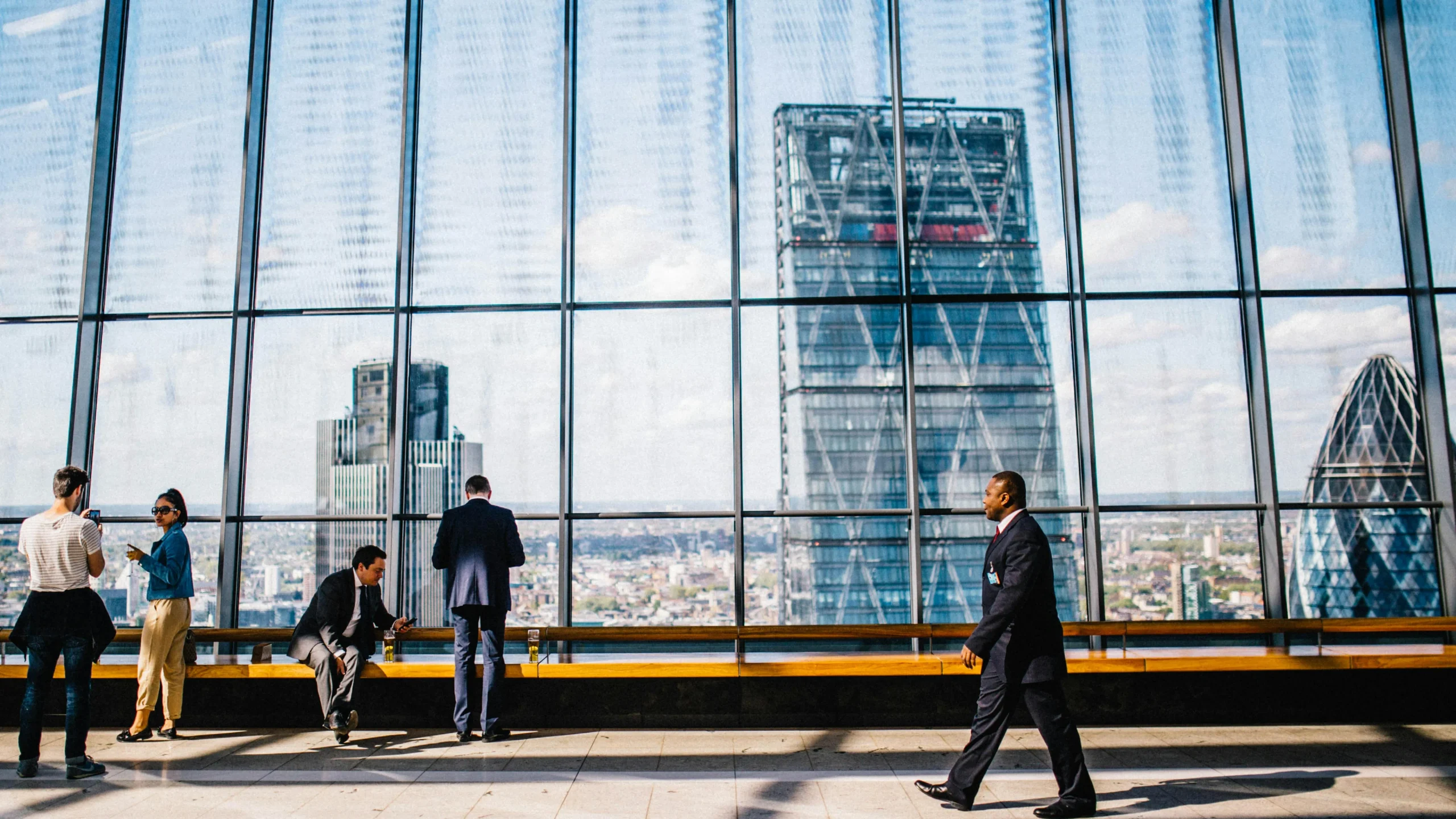 Business professionals in a modern office against a London skyline view.