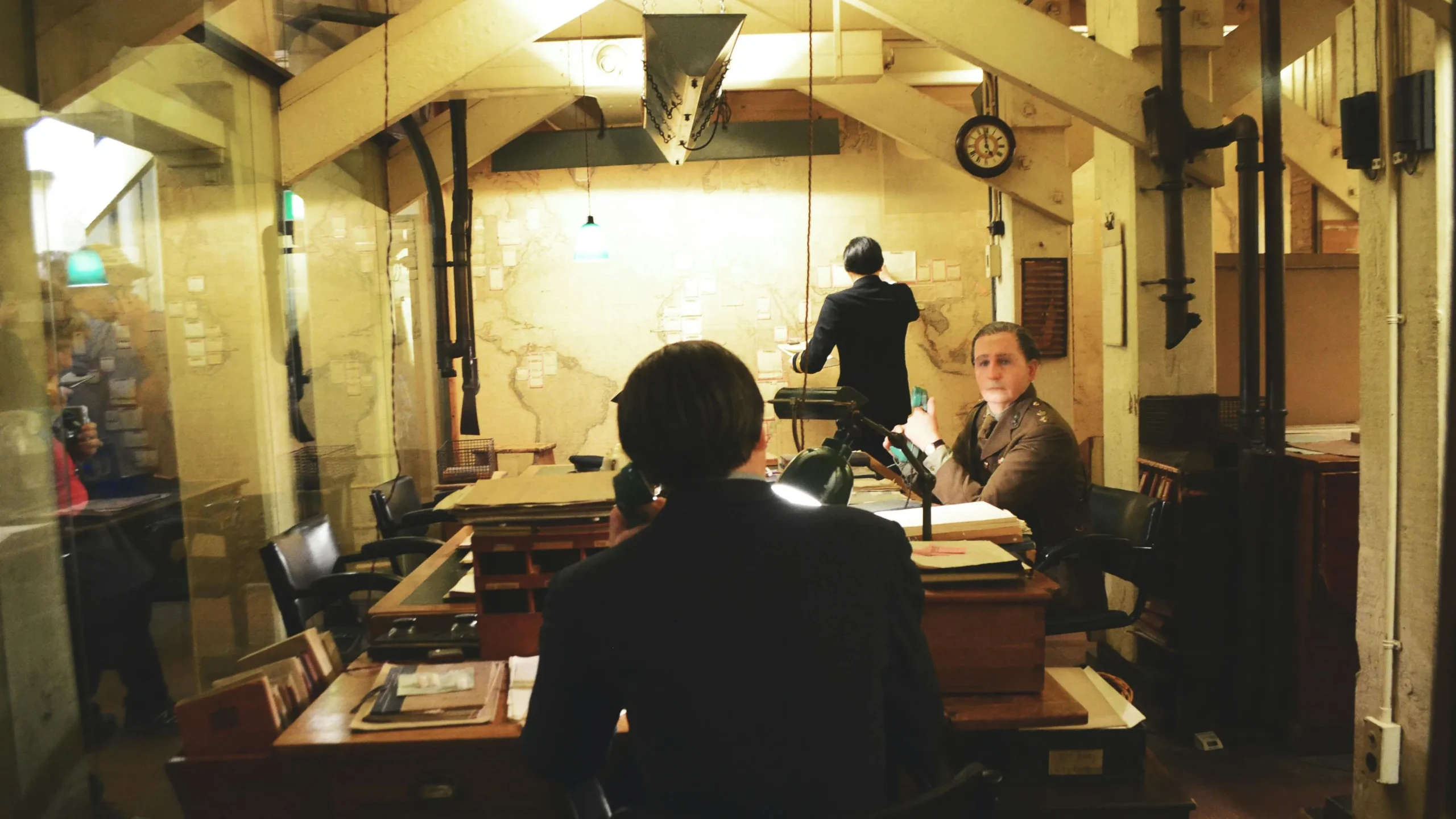 Vintage scene of officers working in a historic war room with maps and desks.